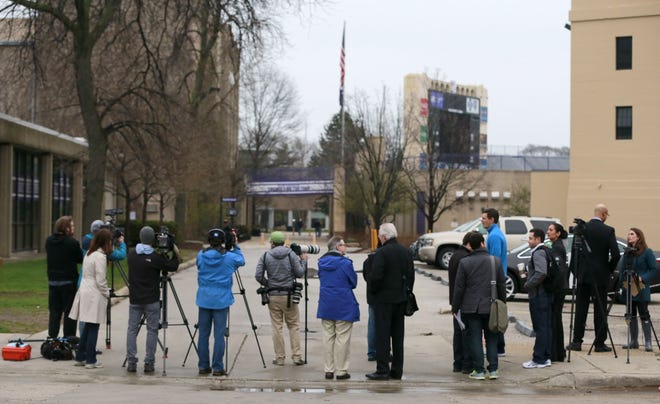 Reporters and photographers between Ryan Field, right, and McGaw Hall, left, where voting is taking place by Northwestern football players on the student athlete union question Friday, April 25, 2014, in Evanston. Northwestern football players cast secret ballots Friday in an on-campus hall adjacent to their home stadium on whether to form the nation’s first union for college athletes.