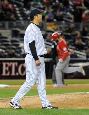 Yankees pitcher Hiroki Kuroda, foreground, reacts Friday as the Angels' Ian Stewart, back right, rounds the bases after hitting a two-run home run during the third inning at Yankee Stadium in New York. (AP Photo/Bill Kostroun)