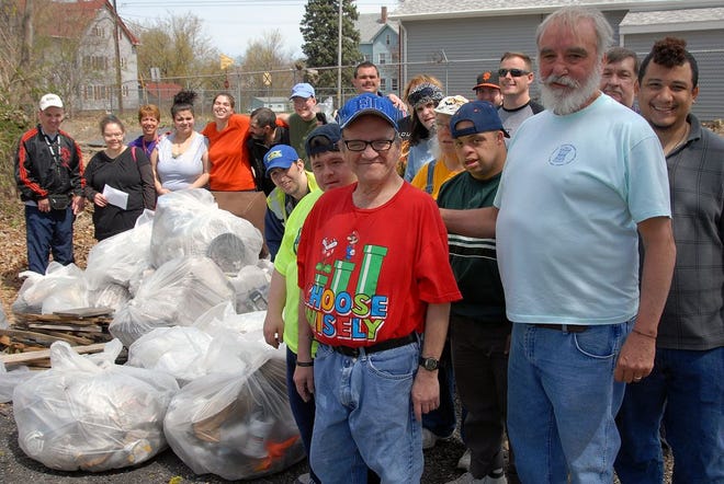 PRIDE Inc. Director of Operations Doug Latham, right, helps collect trash with volunteers on Friday as part of Taunton's Earth Day observance.