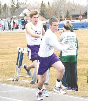 Pickford’s Justin Portice, left, hands the baton to teammate Ian Firack during the 3200 relay at the 13th annual Web Morrison Invitational Saturday.