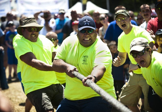 Fireman Ricky Olivas, center, competes in the tug of war during the Battle of the Badges at the Fayetteville Dogwood Festival on Saturday, April 26, 2014.