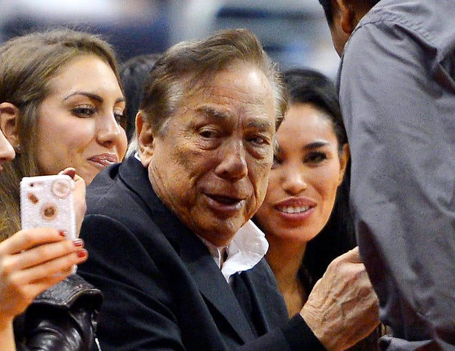 The NBA is investigating a report of an audio recording in which a man purported to be Clippers owner Donald Sterling (center) makes racist remarks.