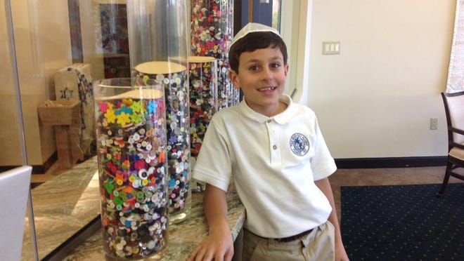 Jonathan Schram, 9, shows buttons that Temple Emanu-El has received from around the world toward its project to collect 1.5 million buttons, each representing a child killed in the Holocaust.