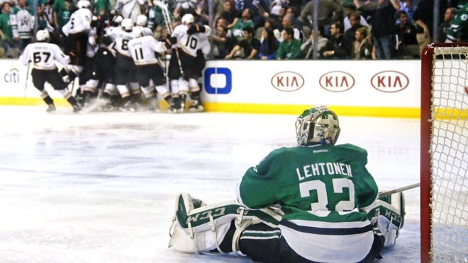 Dallas Stars goalie Kari Lehtonen sits disconsolately on the ice as the Anaheim Ducks celebrate their 5-4 overtime victory Sunday in Game 6 to clinch the NHL Western Conference quarterfinal series. (Louis DeLuca/Dallas Morning News/MCT)