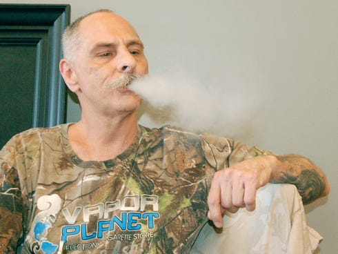 Deric Caselli exhales vapor from his e-cigarette while at Vapor Planet Monday afternoon. Caselli hasn’t had a traditional cigarette since he became a regular customer at Vapor Planet last November.