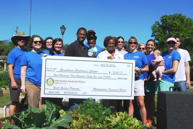 Members of the Metropolitan Savannah Rotary Club present a check for $9,261.77 to representatives from the Greenbriar Children's Center at the site of Greenbriar's new Community Garden built by Rotary members.