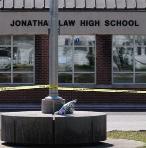 A bouquet of flowers lay outside Jonathan Law High School in Milford, Conn., Friday, April 25, 2014, where a 16-year-old girl was stabbed to death earlier. A teenage boy is in custody, and police are investigating whether she was stabbed because she declined to be his date at the junior prom. Schools Superintendent Elizabeth Feser identified the girl as Maren Sanchez.