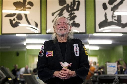 Willie Nelson, the country music icon who turns 81 this week, smiles as he receives his fifth-degree black belt in the martial art of Gong Kwon Yu Sul on Monday, April 28, 2014, in Austin, Texas. (AP Photo/Austin American-Statesman, Ralph Barrera)