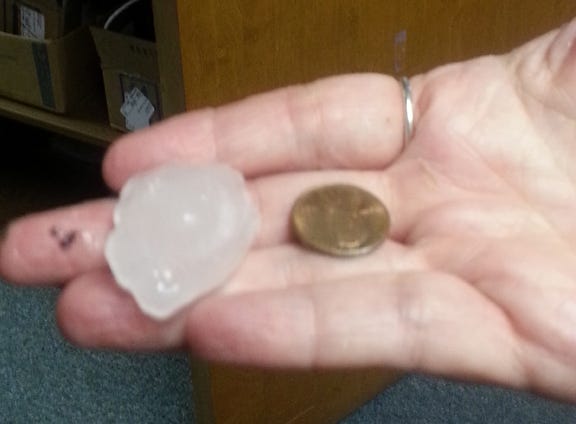 Sonja Gaskins holds a piece of hail that fell in Cove City on Tuesday before a tornado briefly touched down.