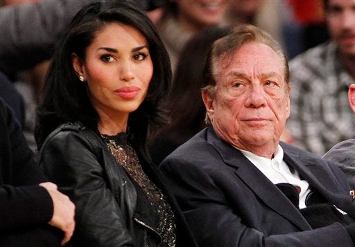 FILE - In this Dec. 19, 2010, file photo, Los Angeles Clippers owner Donald Sterling, right, and V. Stiviano, left, watch the Clippers play the Los Angeles Lakers during an NBA preseason basketball game in Los Angeles. NBA Commissioner Adam Silver is intent on moving quickly in dealing with the racially charged scandal surrounding Clippers owner Sterling. The NBA league will discuss its investigation Tuesday, April 29, 2014, before the Clippers play Golden State in Game 5 of their playoff series.