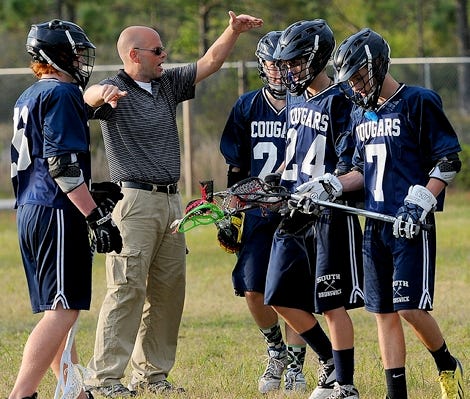 South Brunswick Cougars head coach talks with his players before the game against the Topsail Pirates on Friday, April 25, 2014, at Topsail High School in Hampstead.