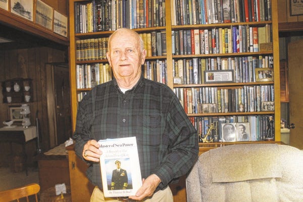 SPECTATOR PHOTO BY GEORGE AUSTIN
Somerset resident James Mullins is seen with one of his favorite books from the about 2,900 books he has related to the U.S. Navy in World War II.