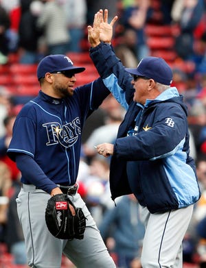Rays manager Joe Maddon (right) high-fives first baseman James Loney after Tampa Bay's 2-1 win over the Red Sox in the first game of a day-night doubleheader on Thursday. The Rays won the nightcap 6-5.