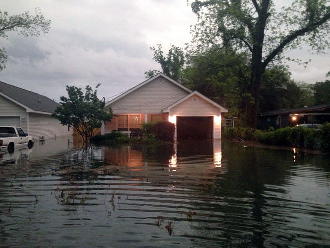 In this photo provided by Kyle Smith, floodwaters surround Smith's home in Pensacola, Fla. on Wednesday, April 30, 2014. Smith had to evacuate his home with his 18-month-old son Tuesday night after severe weather hit the Florida Panhandle, causing widespread flooding.