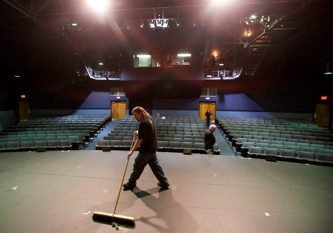 Garrett Henning, assistant stage manager, sweeps the stage at the Ocala Civic Theatre in 2012.