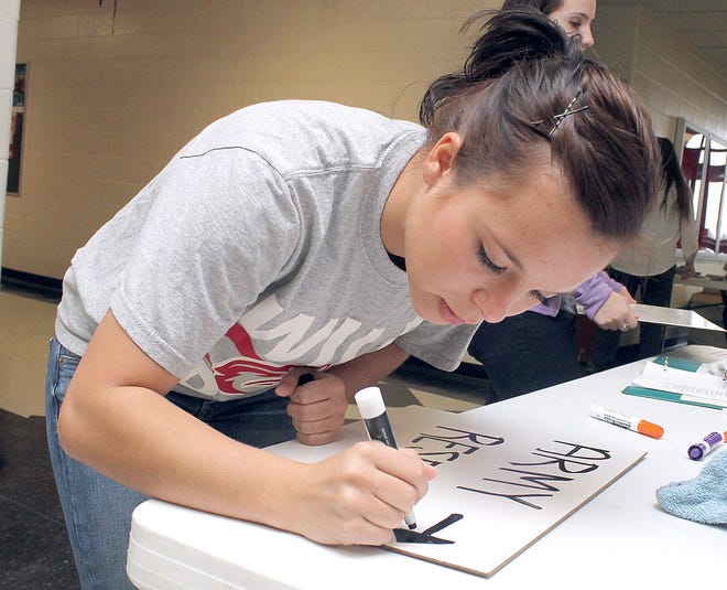 Jonesville High School senior Victoria Payn writes on a white board during College Decision Day 2014. Seniors at the school and around the state spent the day declaring where they would attend college next year. Payn will be going to the Army National Guard before attending Indiana Wesleyan. ANDY BARRAND PHOTO