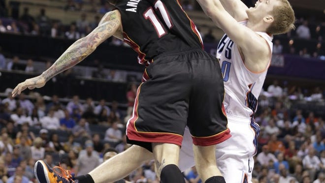 Charlotte Bobcats' Cody Zeller, right, is fouled by Miami Heat's Chris Andersen, left, during the first half in Game 4 of an opening-round NBA basketball playoff series in Charlotte, N.C., Monday, April 28, 2014. (AP Photo/Chuck Burton)