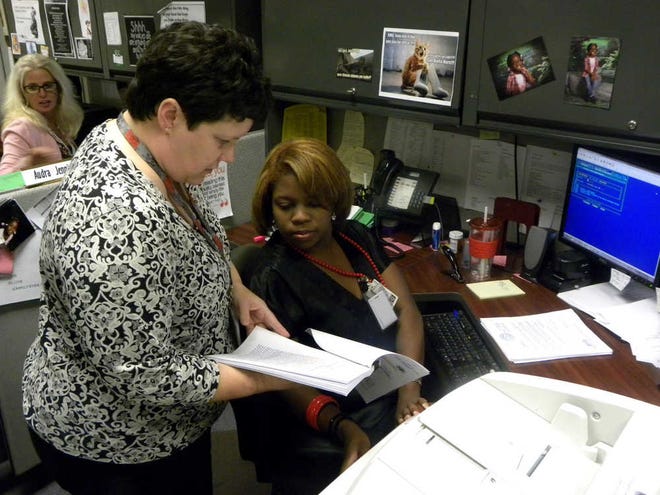 Marcus E. Howard/Savannah Morning News Chatham County Superior Court judicial case managers Andrea Byington, left, and Nikki Clark review a document. The county and city of Savannah are looking to unify the courts under one, paperless case managent computer system.