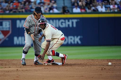 Atlanta Braves' Justin Upton (8) comes up safe at second base after San Francisco Giants shortstop Brandon Crawford could not handle the throw after Evan Gattis reached on a force attempt during the second inning of a baseball game, Saturday, May 3, 2014, in Atlanta.