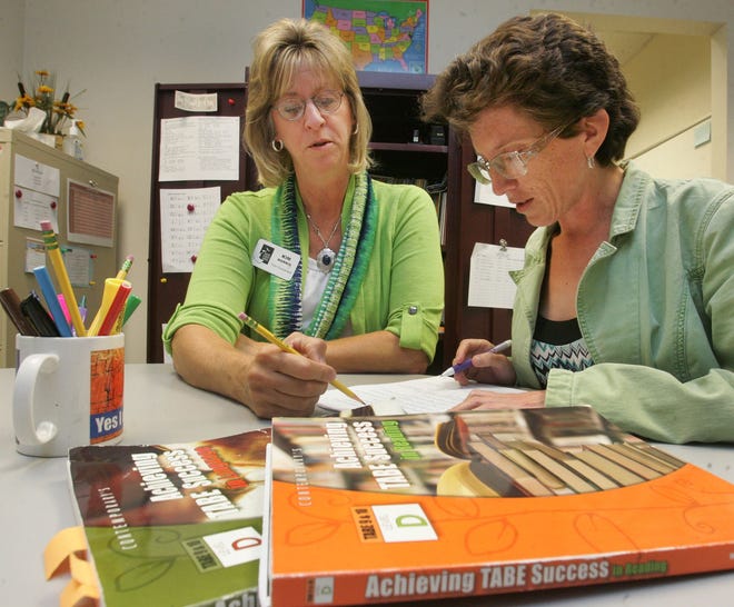 Kim Morris, volunteer coordinator for the Volusia Literacy Council, at left, works with Shannon Voelbel last week in the adult education building at Daytona State College.
