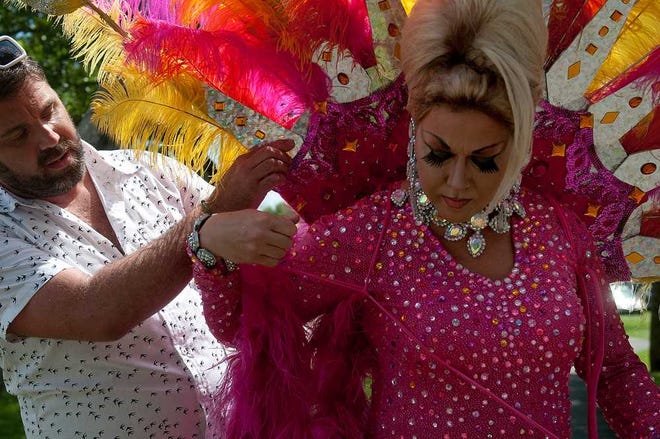 Matt Woods, left, helps Kristina Foxx adjust her dress before the start of the Robert Harper Rainbow Fest Parade on Tybee Island on Saturday afternoon. Approximately 12 local businesses participated in the first year of the parade.