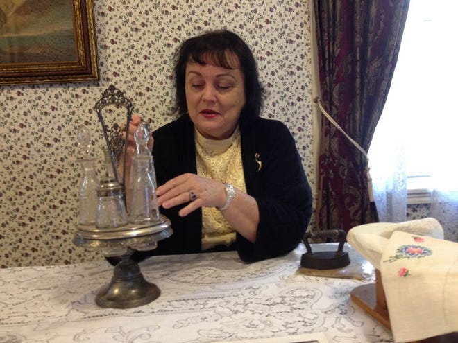 Shelly Dziedzic, a Lizzie Borden historian and a tour guide at the Lizzie Borden Bed & Breakfast in Fall River, holds an antique table decoration. Dziedic said that all furniture and other embellishments in the house must be both “historically correct and practical."