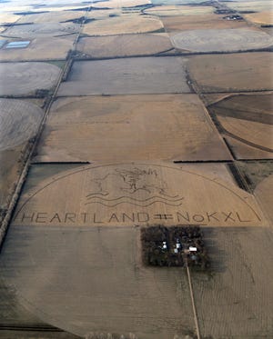 In this photo provided by Lou Dematteis, a huge crop art image protesting the proposed Keystone XL pipeline covers an 80 acre corn field outside of Neligh, Neb., on April 12, 2014. The image, which lies on the proposed pipeline route, was created by the farmers, ranchers and Native American tribes of the Cowboy and Indian Alliance in collaboration with artist John Quigley.