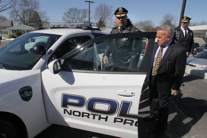 In March, North Providence Mayor Charles Lombardi (right) looks over some of the police cruisers the town of North Providence purchased with Google settlement money. At left is Police Chief Paul Martellini and at right is North Providence police officer Christopher Pelagio.