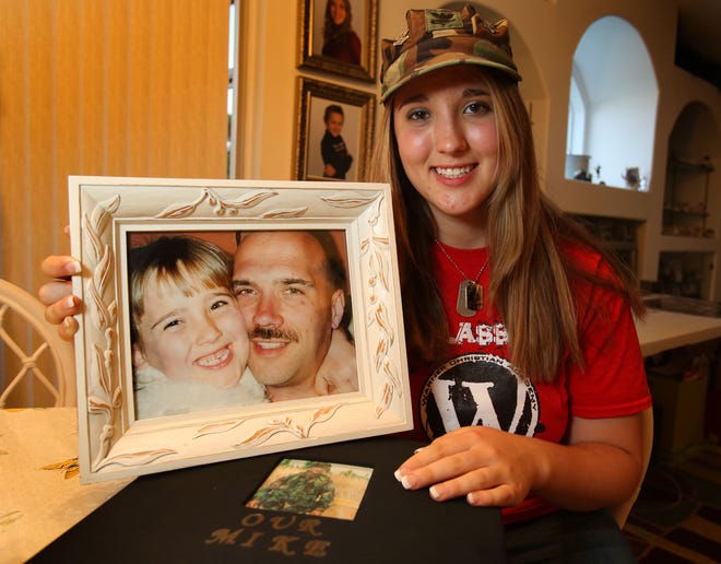 Brandi Anderson holds a photo of her and her father, who was killed in Iraq. She won a scholarship from the Children of Fallen Patriots Foundation.