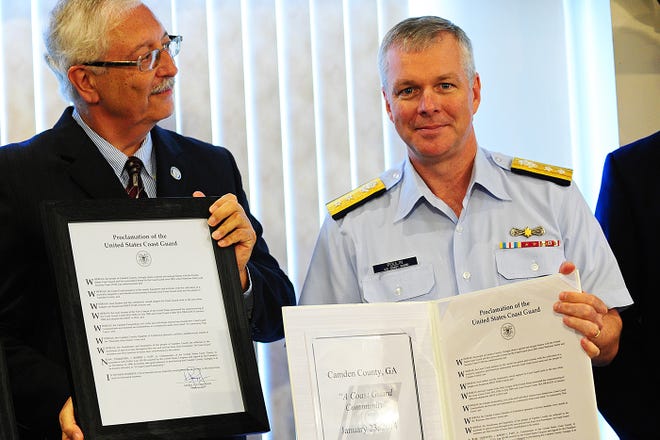 Coast Guard Rear Adm. Steven Poulin, right, with St. Marys Mayor John F. Morrissey displays the official proclamation naming Camden County a Coast Guard Community Friday, April 25.