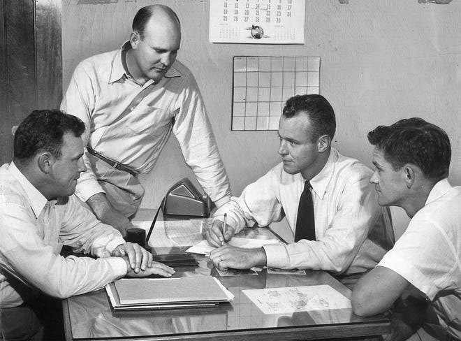Bud Wilkinson (second from right) chats with his 1949 staff: Gomer Jones (left), Pop Ivy (standing) and Bill Jennings. (Oklahoman archive photo)