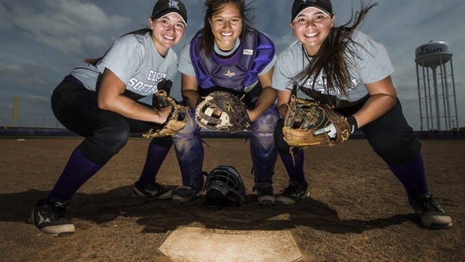 Elgin senior catcher Andrea Gonzales, center, poses with her twin sisters, Victoria, left, and Theresa, on Wednesday. Victoria and Theresa play second and third base, respectively for the Lady Cats softball team, which opens a Class 4A regional-quarterfinal series on Friday.