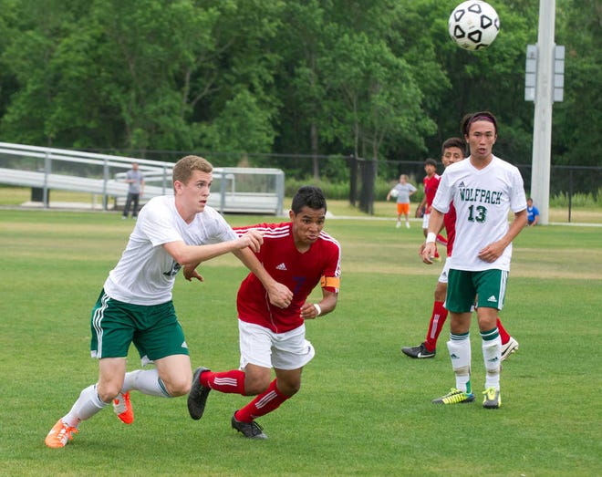 Greenbrier's Bryan Thompson and Heritage's Edel Ramos race after the ball, past Greenbrier's Nick Woo.
