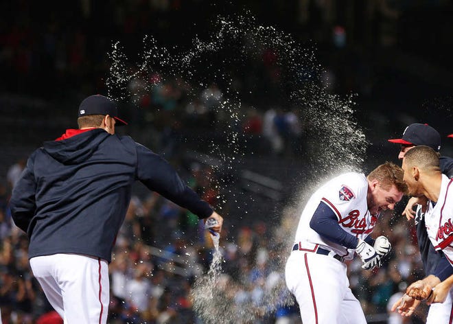 Atlanta's Freddie Freeman is doused with water after driving in the game-winning run with a base hit in the 10th inning.