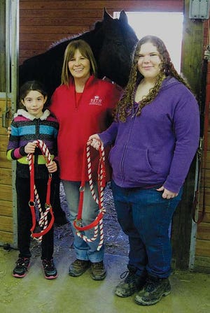 Submitted photo - Pictured from left are 4-H member Amanda Fisher, 4-H Club Leader Nancy Van Wyk and 4-H member Adriana Bauer, with GAIT’s horse Montana, ready to try out the “fire halter.”
