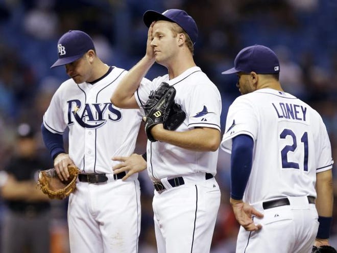 Tampa Bay Rays relief pitcher Brad Boxberger, center, wipes his forehead as he waits with third baseman Evan Longoria, left, and first baseman James Loney, right, for manager Joe Maddon to take him out of the game against the Cleveland Indians during the sixth inning of a baseball game Friday, May 9, 2014, in St. Petersburg, Fla.