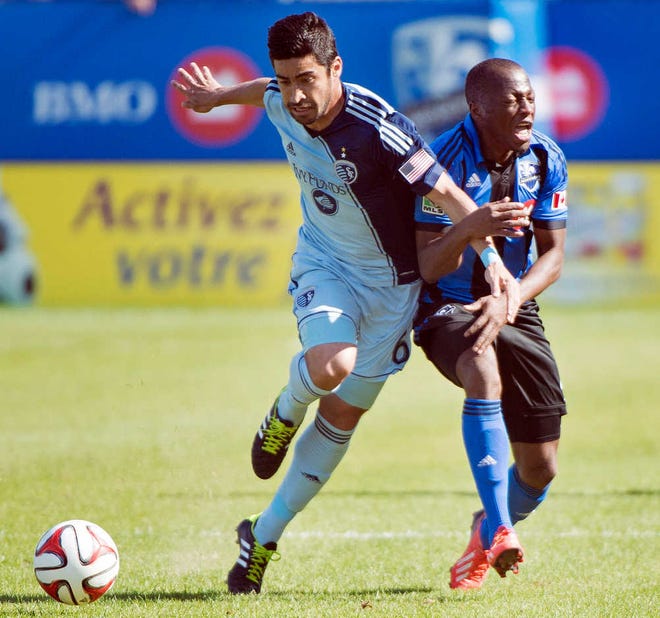 Montreal Impact's Sanna Nyassi, right, and Sporting Kansas City's Paulo Nagamura battle for the ball during the first half of an MLS soccer game in Montreal, Saturday.