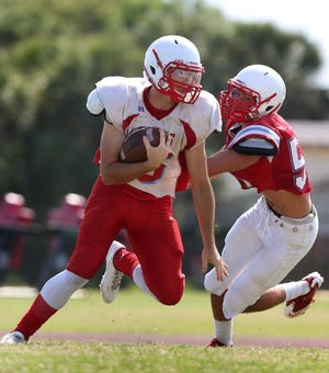 Matanzas transfer Jeremiah Wilson tries to elude a defender during Seabreeze’s spring practice Thursday. Wilson threw for 934 yards and five TDs last season.