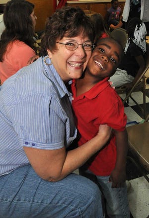 ADVANCE FOR MONDAY, MAY 12 AND THEREAFTER - Andrea Minolfo, a retired teacher and volunteer with Laces 4 Love, has a new friend in Head Startt student Siyontrez Gaston after he got new shoes donated from by the organization, one of dozens of children who received them at Head Start in Aiken. Laces 4 Love is adding Guatemala to its charitable work for the first time in January 2015. Later this year, the volunteers will take as many as 600 pairs of shoes to rural villages in Nicaragua. (AP Photos/Aiken Standard, Rob Novit)