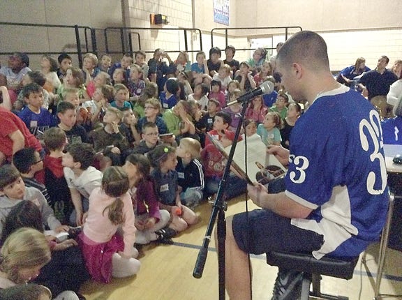 Kennebunk High School senior Nicco DeLorenzo reads his favorite children's story "Family Huddle" to more than 200 children during a reading celebration at Sea Road School last Thursday.