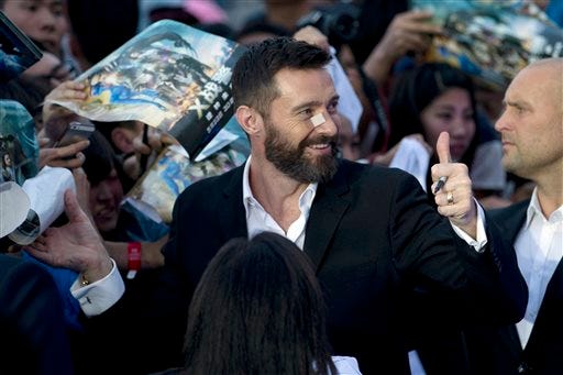 Australian actor Hugh Jackman gives a thumbs up as he signs autographs for fans during the red carpet for his latest movie "X-Men:Days of Future Past" in Beijing, China, Tuesday, May 13, 2014. Jackman said Tuesday he wasn't ready to give up his 14-year role as the X-Men character Wolverine as he visited China to promote the franchise's latest movie, which has local elements intended to appeal to the massive Chinese audience. (AP Photo/Ng Han Guan)