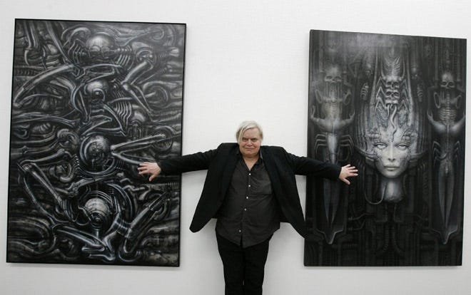This 2007 picture shows Swiss artist H.R. Giger posing with two of his works at the art museum in Chur, Switzerland.