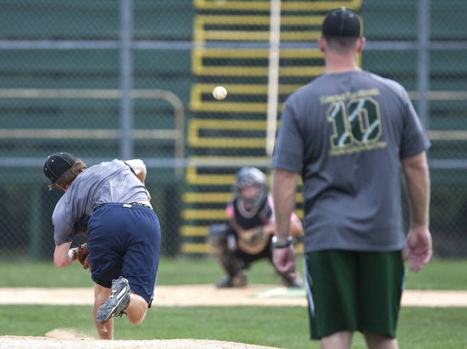Trinity Catholic's head coach Tommy Bond (far right) watches as pitcher Brandon Reitz (far left) throws a practice pitch to catcher Jaime Suarez during practice at Trinity Catholic High School May 12, 2014. The Celtics head to Fort Myers Wednesday for the state semifinals against Fort Myers Bishop Verot.