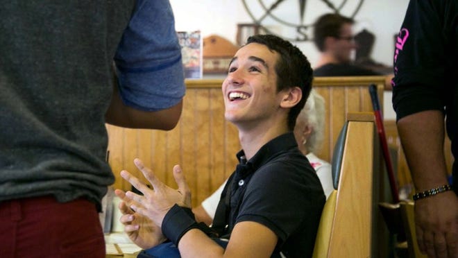 Seminole Ridge high School student Justin Perez is greeted by friends at a fundraiser for him at Butterfields cafe in Royal Palm Beach, Florida on April 29, 2014. Perez was seriously injured while participating in shop class at the school. (Allen Eyestone / The Palm Beach Post)