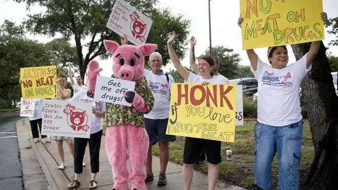 Members of The Consumers Union protest during the opening of a Trader Joe’s store last year in Austin.