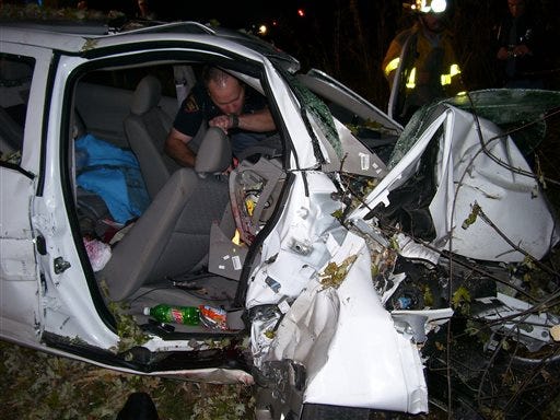 In this Oct. 24, 2006 photo provided by the St. Croix County Sheriff's Office, police investigate the wreckage of a 2005 Chevrolet Cobalt that crashed in St. Croix County, killing Natasha Weigel, 18, and Amy Lynn Rademaker, 15, and injuring the 17-year-old driver, Megan Ungar-Kerns. The vehicle's ignition was found in the "accessory" position and the air bags didn't deploy. General Motors' recent recall of 2.6 million small cars, including the 2005 Cobalt, has shed light on an unsettling fact: Air bags might not always deploy when drivers _ and federal regulators _ expect them to. (AP Photo/St. Croix County Sheriff's Office)