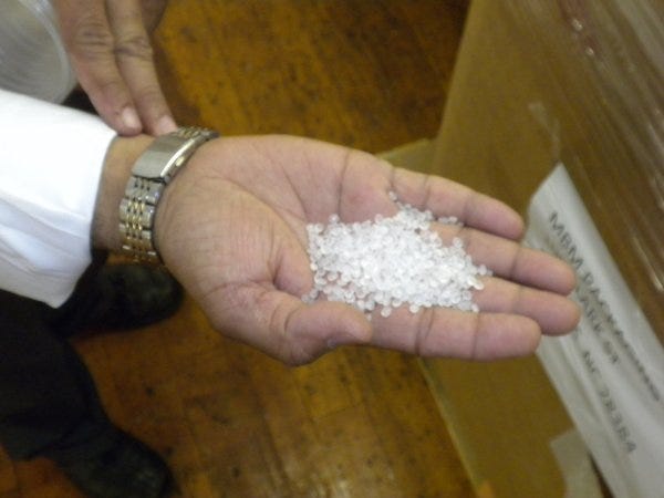 Sunil "Sonny" Patel shows a handful of plastic pellets that will become plastic cups. The company, MBM Packaging LLC, will manufacture about 500,000 cups per day.