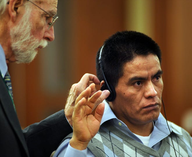 Nicolas Dutan Guaman, right, was sworn in as the interpreter adjusts his headphones during the first day of his trial, last Wednesday, in Worcester Superior Court. Daily News Staff File Photo/ Allan Jung