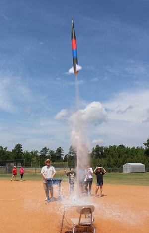 Evans Middle School science teacher David Phillips fires a rocket constructed by sixth-grade science pupils.
