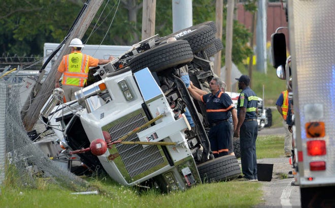 Workers prepare to turn over an Erycson Crane truck after it flipped near the intersection of New Savannah Road and Skyview Drive early Wednesday morning. Passenger Eryc Jordan Riddle, of Grovetown, died in the accident.